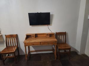 - un bureau avec deux chaises et une télévision murale dans l'établissement Guest Room, à Boksburg