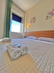 a bedroom with a large bed with towels on it at Hotel Valente in Ortona