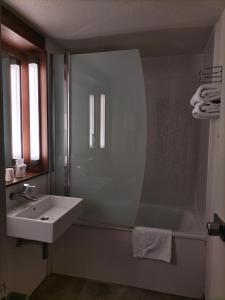 La salle de bains est pourvue d'une douche, d'un lavabo et d'une baignoire. dans l'établissement Campanile Toulouse Nord l'Union, à LʼUnion
