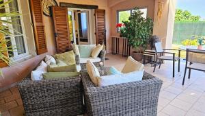 patio z 2 wiklinowymi krzesłami i stołem w obiekcie Elégant-Cosy 2P55M2 dans bas de villa provençale ! w mieście Villeneuve-Loubet
