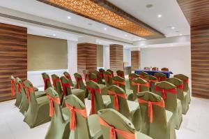 einen Konferenzraum mit grünen Stühlen und einem Podium in der Unterkunft Click Hotel Vadodara 2 Mins from Railway Station in Vadodara