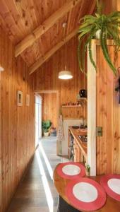 una cocina con paredes de madera y una mesa en una cabaña en Tinyhouse Licanray, en Licán Ray
