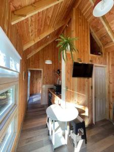 Zimmer mit einem Tisch und einem TV in einer Hütte in der Unterkunft Tinyhouse Licanray in Licán Ray