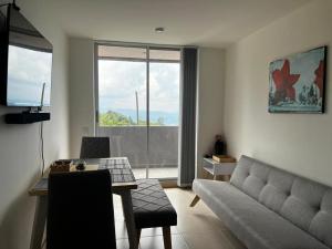 een woonkamer met een bank en een tafel bij Hermoso apartamento la Francia 3 habitaciones in Manizales