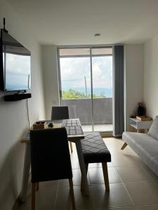 een woonkamer met een tafel en een bank bij Hermoso apartamento la Francia 3 habitaciones in Manizales