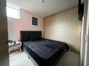 1 dormitorio con 1 cama negra en una habitación en Hermoso apartamento la Francia 3 habitaciones en Manizales