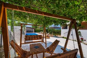 a patio with chairs and a table under a tree at Villa Gabi in Pridraga