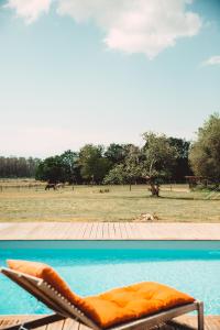 an orange couch sitting on top of a pool at Le Ranch Kabahina Golf in Saint-Geours-de-Maremne