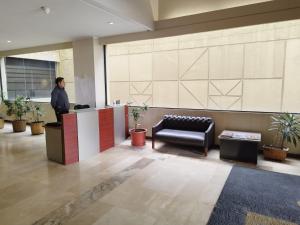 a man standing at a counter in a lobby at Suite Akros in Quito