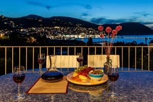 una mesa con un plato de comida y dos copas de vino en Sunshine Pool Villa near the Sea, en Skopelos Town