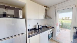 eine weiße Küche mit einem Kühlschrank und einer Spüle in der Unterkunft Dorada 284950-A Murcia Holiday Rentals Property in Roldán