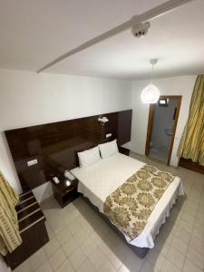 - une chambre avec un grand lit et une tête de lit en bois dans l'établissement Grand Atlas Hotel, à Pamukkale