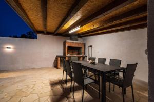 a dining room with a table and chairs and a fireplace at Villa Gabi in Pridraga