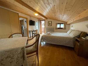 a bedroom with a bed and a table in a room at Ambassador Rooms in Bormio, SOLO CAMERA SENZA COLAZIONE in Bormio