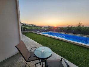 a patio with a table and chairs and a swimming pool at Villa Dionisia with private pool in Roumelí
