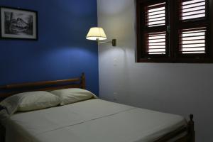 a bedroom with a bed with a blue wall and a lamp at Hersher Studio's & Apartments in Willemstad