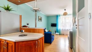 a kitchen with a counter and a living room at Teleexpresu Apartamenty PIAMOLA in Krynica Morska