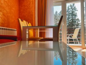 une table et des chaises en verre dans une chambre avec fenêtre dans l'établissement Lux JL apartment, à Žabljak