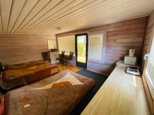 a room with two beds in a room with wooden walls at Sodyba Duobys in Alanta
