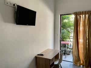 a room with a table and a television on the wall at Amalthia Hotel Apartments in Rethymno