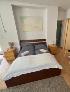 a bedroom with a bed with two pillows on it at Wash House Apartman in Győr
