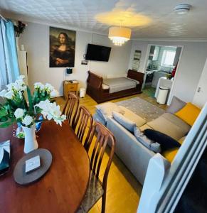 ein Wohnzimmer mit einem Sofa und einem Tisch in der Unterkunft Villa sea view 3-bed heated pool eat bar kids park in Lowestoft
