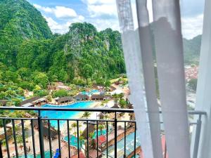 een balkon met uitzicht op een resort met een zwembad bij Hotspring 2 Room 1512 Suite @ Sunway Onsen with Theme Park View 4 pax in Tambun