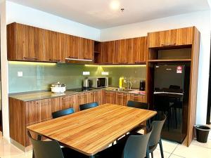 una cocina con armarios de madera y una mesa y sillas de madera. en Hotspring 2 Room 1512 Suite @ Sunway Onsen with Theme Park View 4 pax, en Tambun