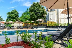 a pool with chairs and umbrellas at a hotel at Emilia Lux Rooms in Vrnjačka Banja