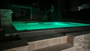 een zwembad 's nachts met groene verlichting bij Villetta de Mar in Civitanova Marche