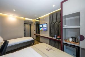 um quarto de hotel com duas camas e uma televisão de ecrã plano em Heaven Premium Hotel İstanbul Airport em Arnavutköy