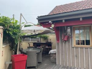 um pátio com uma mesa e um guarda-chuva em La Cabane em Andernos-les-Bains