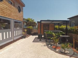 un patio con plantas, una valla y un edificio en Little bouddha, en Hermanville-sur-Mer