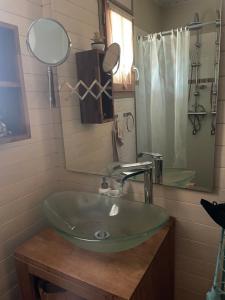 uma casa de banho com um lavatório verde e um espelho em La Cabane em Andernos-les-Bains