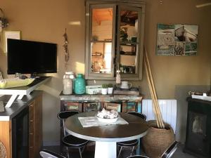 uma cozinha com uma mesa e uma televisão e uma mesa e cadeiras em La Cabane em Andernos-les-Bains