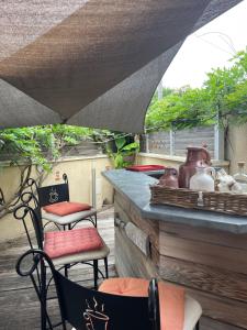a patio with two chairs and a counter with vases at La Cabane in Andernos-les-Bains +6 photos