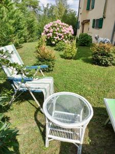 uma cadeira branca e uma mesa e uma cadeira e flores em Casa relax immersa nel verde della natura em Casalborgone
