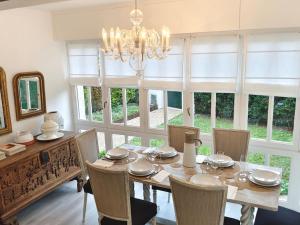 uma sala de jantar com uma mesa e cadeiras e um lustre em Villa Familiar con encanto em Hondarribia