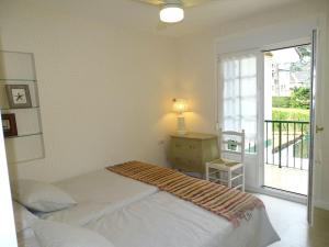 um quarto com uma cama, uma mesa e uma janela em Villa Familiar con encanto em Hondarribia