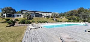 a house with a swimming pool on a wooden deck at Villa Serrana - Mesón de las cañas in Villa Serrana