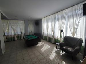 a living room with a pool table in front of windows at Anker - Podczele in Kołobrzeg