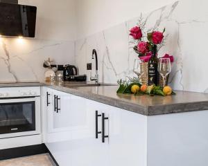 a kitchen with white cabinets and a counter with roses at AV Suites in Lakíthra