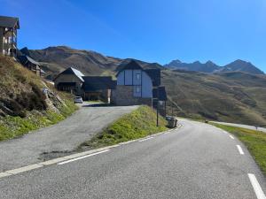 an empty road with a house on the side of a hill at Piste verte à Peyragudes T2 4-6P, proche Loudenvielle in Loudenvielle