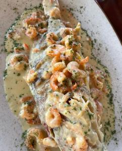 a plate of food with shrimp in a sauce at Cabaña The Sunset in Santa Marta +17 photos