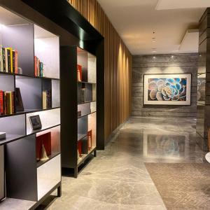 a library with bookshelves and a painting on the wall at Apartemen springwood in Pakulonan Dua