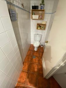 a bathroom with a toilet and a tile floor at Casa Montigar in Chiclana de la Frontera