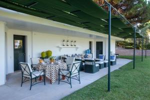 een patio met een tafel en stoelen en een bank bij House with pool and elegant garden in Estoril in Estoril