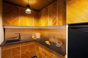 eine Küche mit Holzschränken und einem schwarzen Kühlschrank in der Unterkunft House with pool and elegant garden in Estoril in Estoril