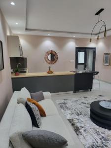 a living room with a white couch and a kitchen at Dakar Dreams Spinelle in Dakar