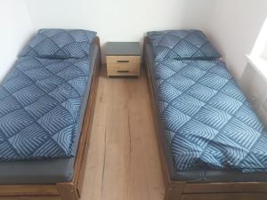 a bedroom with two beds and a night stand at Wlen Rynek II in Wleń